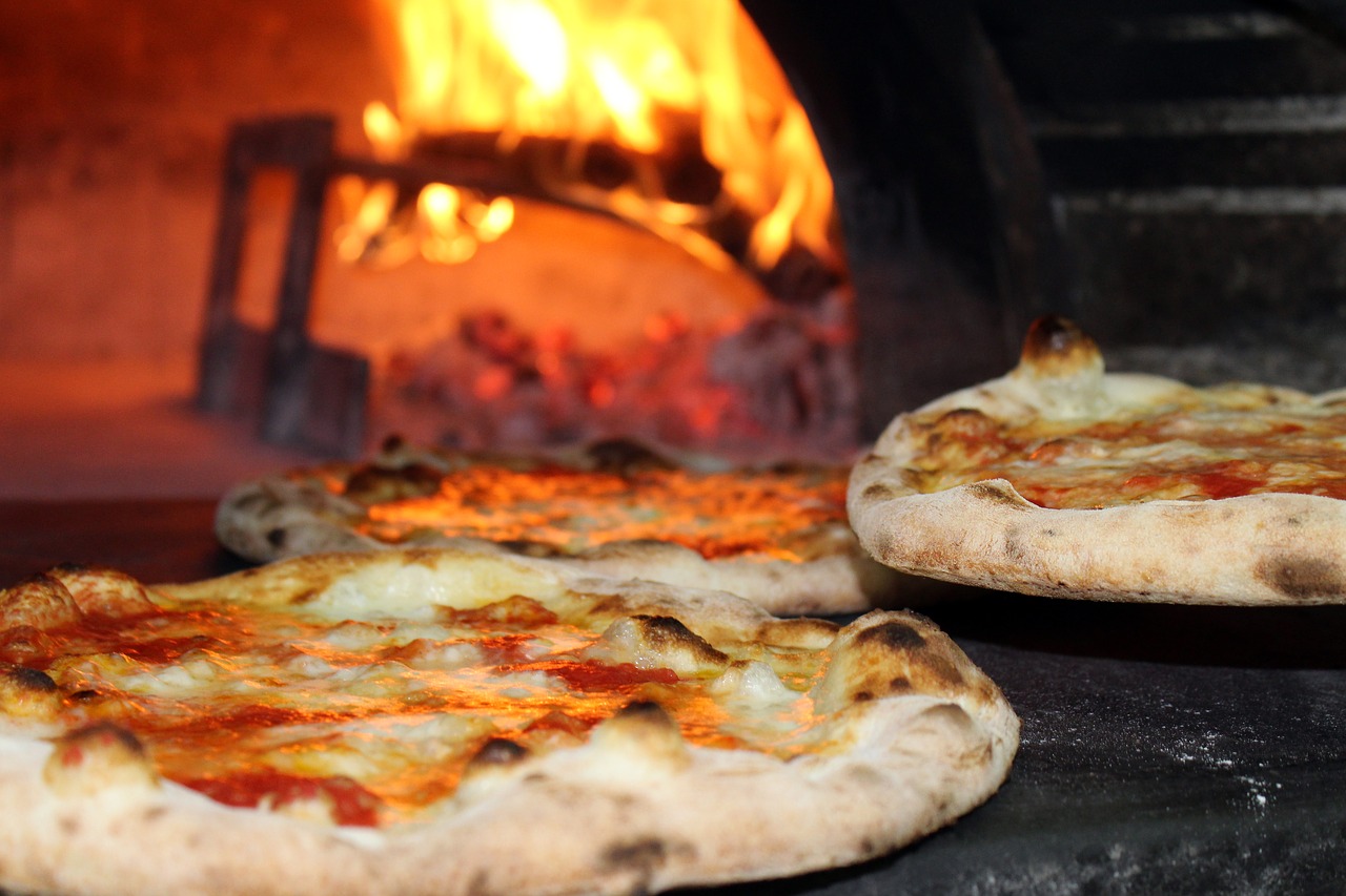 Een pizza bereid je zelf in een houtgestookte pizza oven